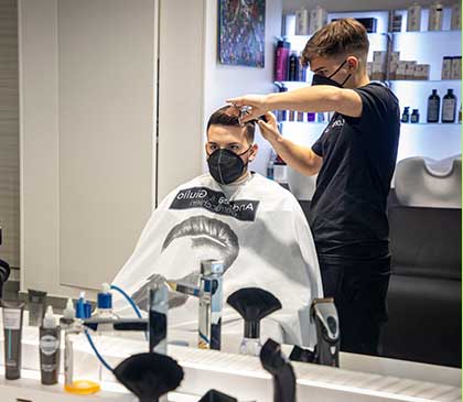 giovane parrucchiere realizza taglio maschile