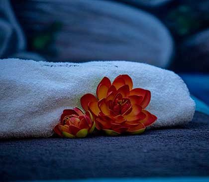 due fior di loto finti e un telo piegato su un lettino del centro estetico di Andrea & Giulio Hair and Relax a Rende