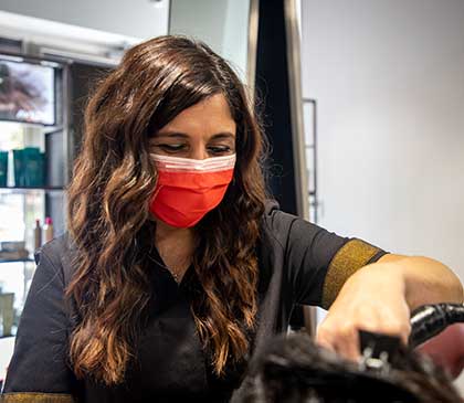 parrucchiera del salone Andrea & Giulio Hair and Relax realizza un acconciatura con il ferro per capelli