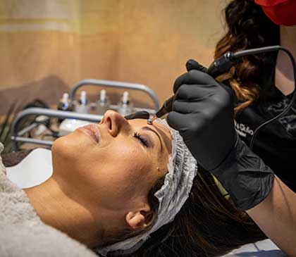 volto di una donna mentre si sottopone ad un trattamento per il ringiovanimento della pelle