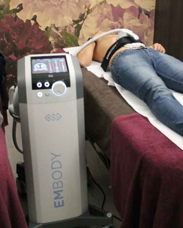 uomo si sottopone ad un trattamento estetico di stimolazione muscolare magnetica