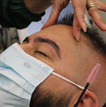 estetista di Andrea & Giulio Hair and Relax effettua epilazione su sopracciglia maschili