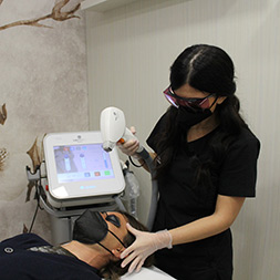 un'estetista di Andrea & Giulio esegue epilazione laser su un viso maschile